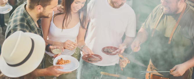 people surrounding table of BBQ food